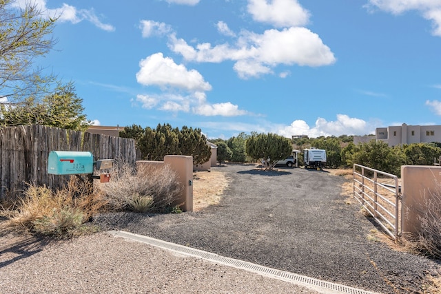 view of road with gravel driveway, a gated entry, and a gate