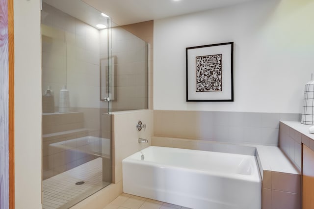 full bath featuring a shower stall, tile patterned flooring, and a garden tub