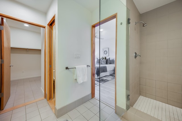 bathroom featuring tile patterned floors, ensuite bathroom, baseboards, and a tile shower