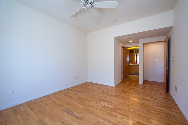 empty room featuring light wood-style floors, baseboards, and a ceiling fan