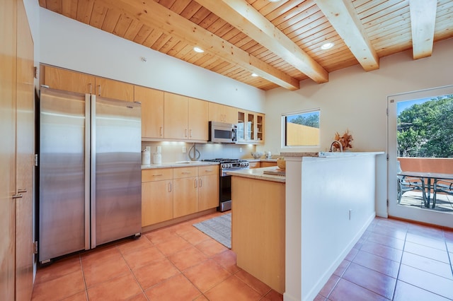 kitchen with a peninsula, appliances with stainless steel finishes, light brown cabinetry, and wooden ceiling