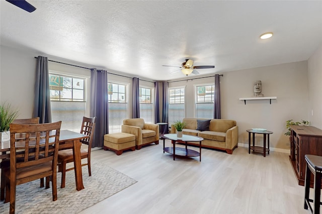living room with a healthy amount of sunlight, light wood-type flooring, and ceiling fan