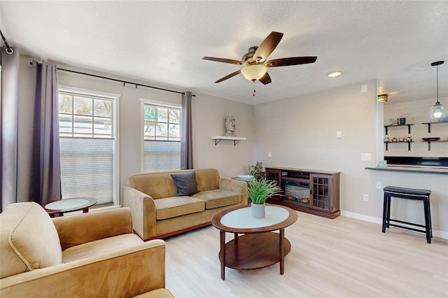 living area featuring recessed lighting, baseboards, a ceiling fan, and light wood-style floors