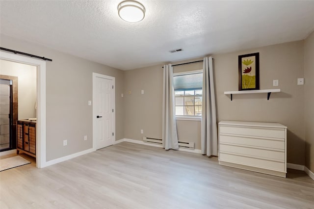 unfurnished bedroom with light wood-style floors, visible vents, a baseboard heating unit, and baseboards