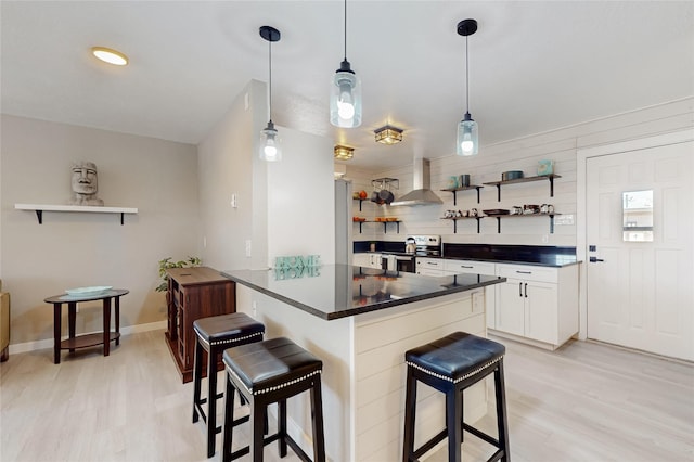 kitchen featuring stainless steel range with electric stovetop, light wood finished floors, a kitchen breakfast bar, and open shelves