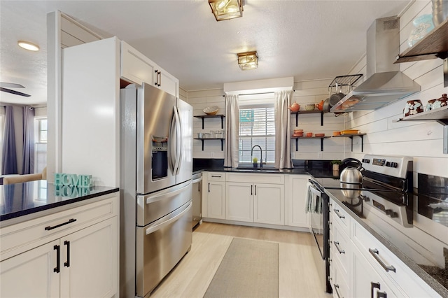 kitchen featuring open shelves, a sink, appliances with stainless steel finishes, island range hood, and light wood-style flooring