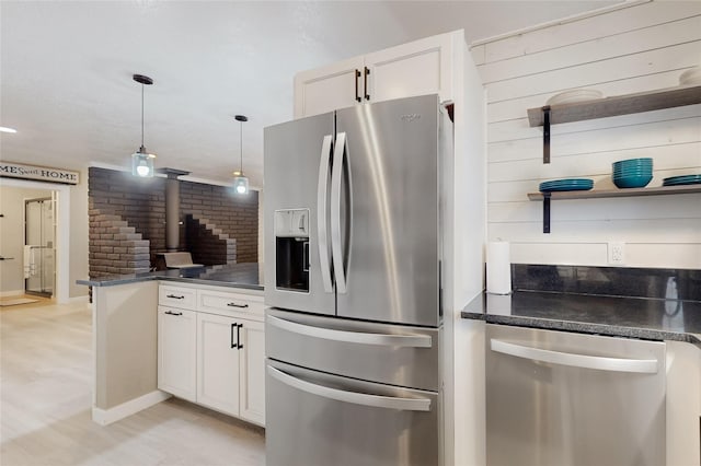 1221B N Orchard, Espanola, NM 87532 - kitchen featuring appliances with stainless steel finishes, white cabinets, a wood stove, hanging light fixtures, and a peninsula