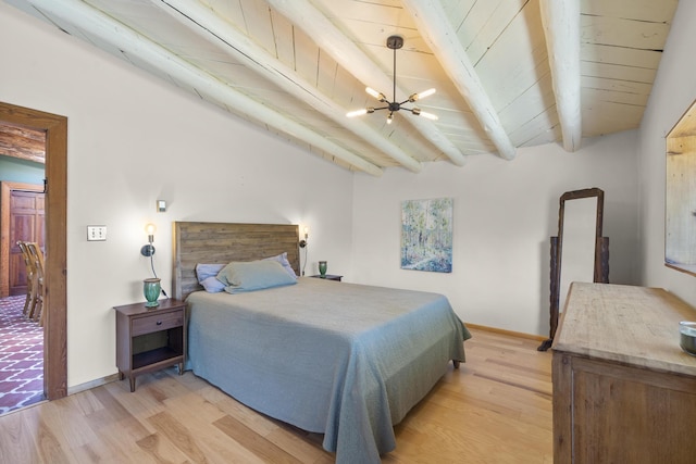 bedroom featuring beamed ceiling, baseboards, light wood finished floors, and a chandelier