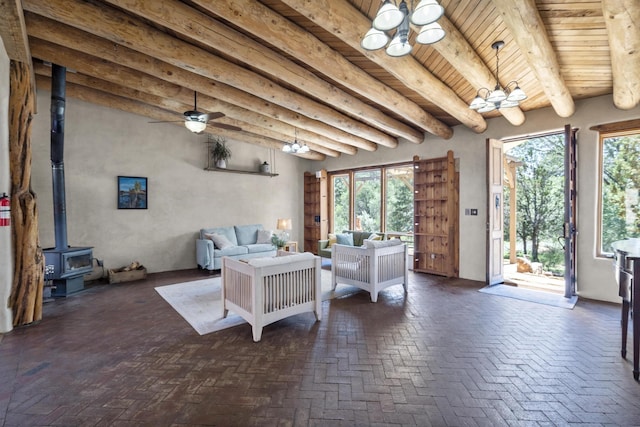 living room with a wood stove, plenty of natural light, wooden ceiling, and beam ceiling