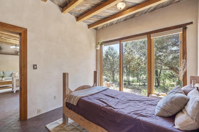 bedroom with brick floor, wood ceiling, and beam ceiling