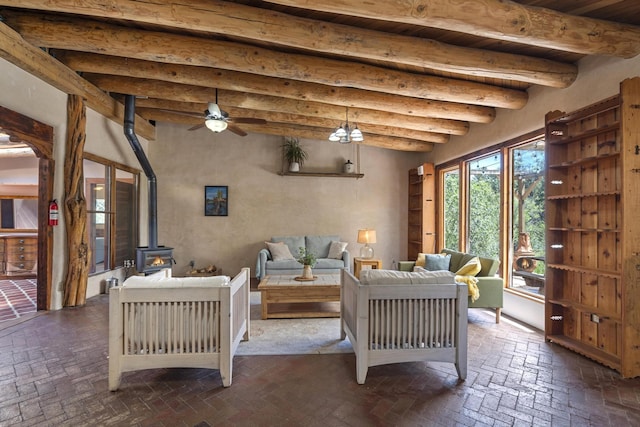 living room with brick floor, a wood stove, ceiling fan, and beam ceiling