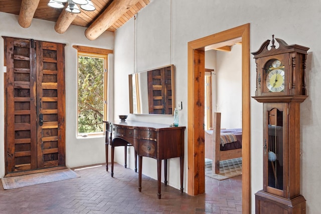 foyer entrance with brick floor, plenty of natural light, and wood ceiling