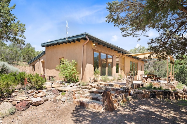 rear view of property with a patio and stucco siding