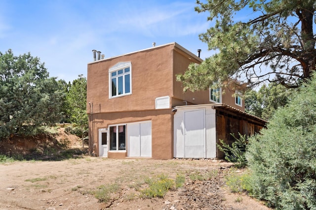 rear view of house with stucco siding
