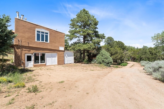 back of property featuring stucco siding