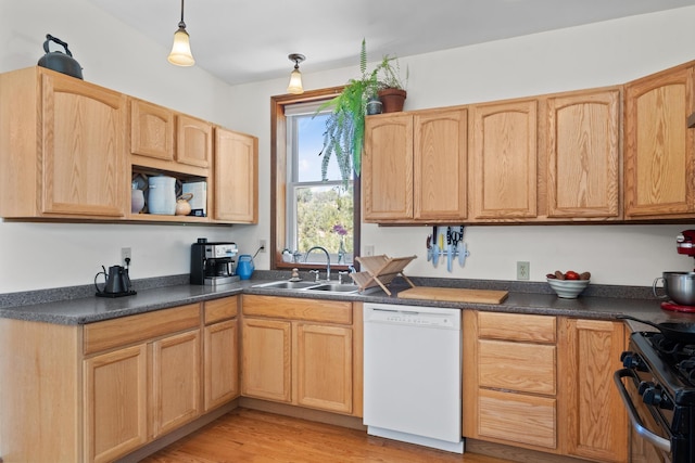 kitchen featuring dishwasher, light brown cabinets, a sink, dark countertops, and light wood-style floors