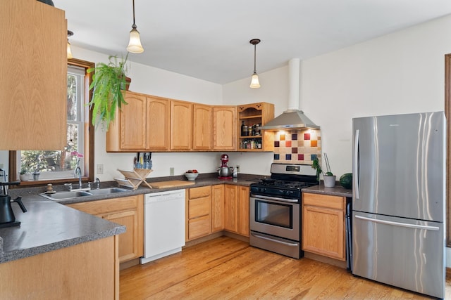 kitchen with a sink, appliances with stainless steel finishes, dark countertops, and a healthy amount of sunlight