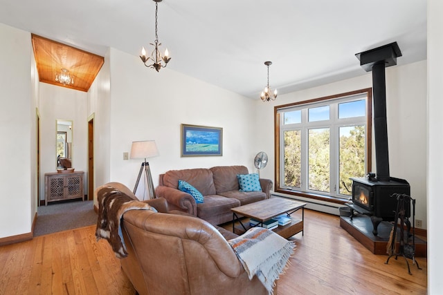 living room with a wood stove, a chandelier, and a wealth of natural light