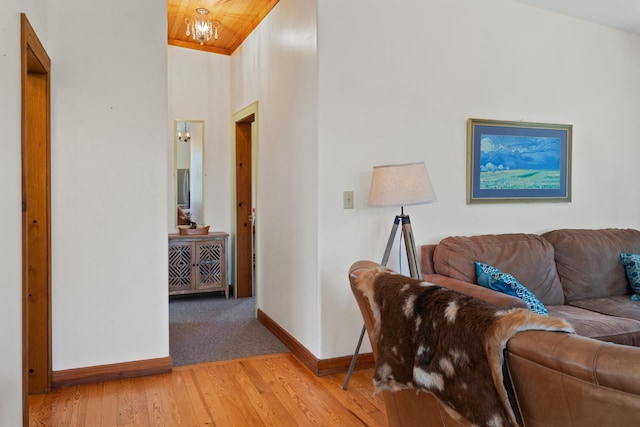 living area with light wood-style flooring, wooden ceiling, baseboards, and vaulted ceiling