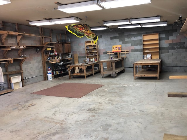 below grade area featuring concrete block wall, a garage, and a workshop area
