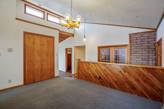 unfurnished living room with high vaulted ceiling, an inviting chandelier, a textured ceiling, carpet floors, and baseboards