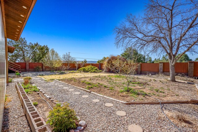 view of yard with a fenced backyard and a garden