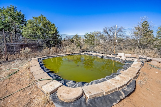 view of swimming pool with fence