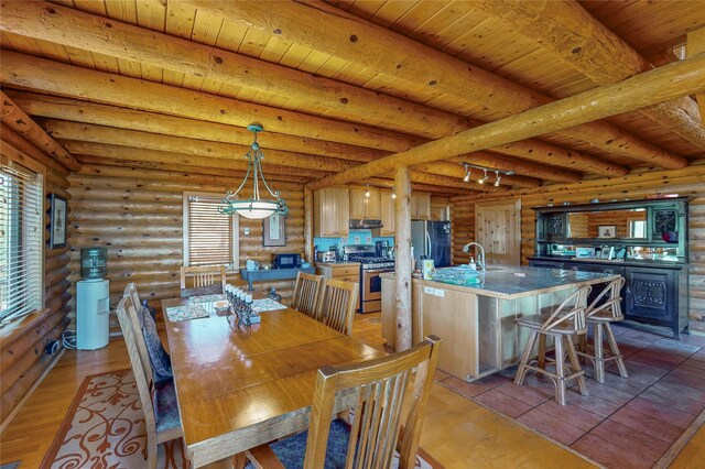 387 County Road B64, Pecos, NM 87552 - dining space featuring beamed ceiling, log walls, wood ceiling, and light wood-style flooring