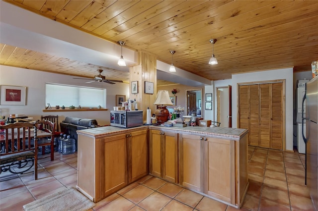 387 County Road B64, Pecos, NM 87552 - kitchen with tile countertops, stainless steel microwave, open floor plan, wood ceiling, and light tile patterned flooring