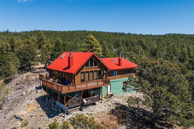 387 County Road B64, Pecos, NM 87552 - back of property with a forest view, log exterior, a chimney, and a wooden deck