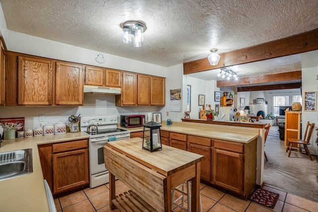 kitchen with butcher block countertops, light tile patterned floors, a peninsula, under cabinet range hood, and white range with electric stovetop