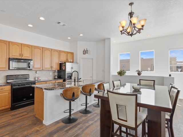 kitchen featuring black appliances, a chandelier, dark wood-type flooring, decorative backsplash, and recessed lighting