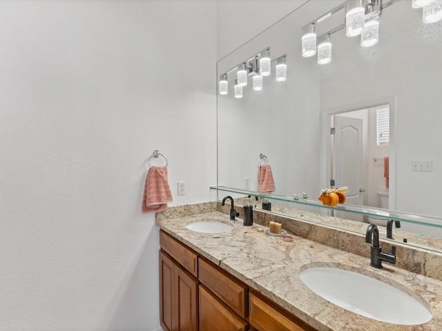 bathroom featuring double vanity and toilet