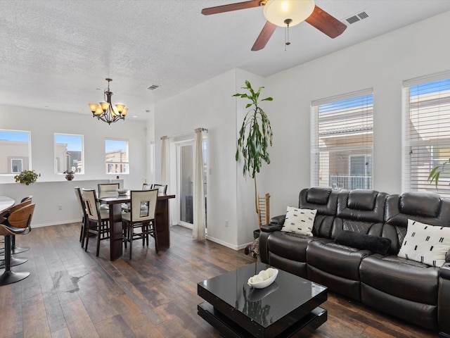 living area with a chandelier, dark wood-style floors, ceiling fan, and a textured ceiling