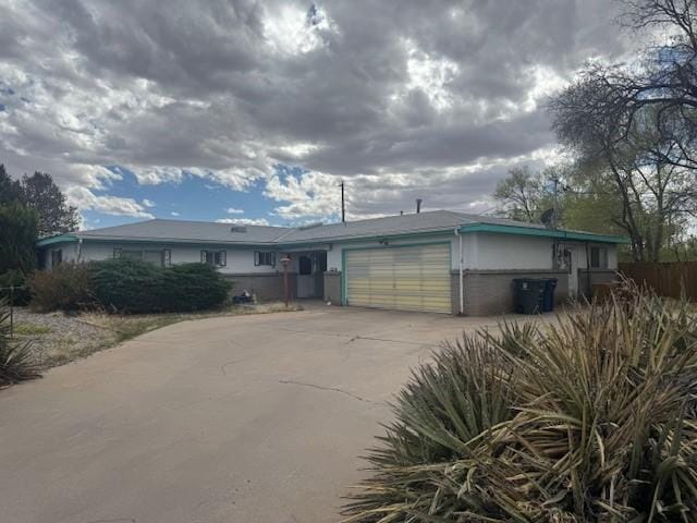 single story home featuring concrete driveway and a garage