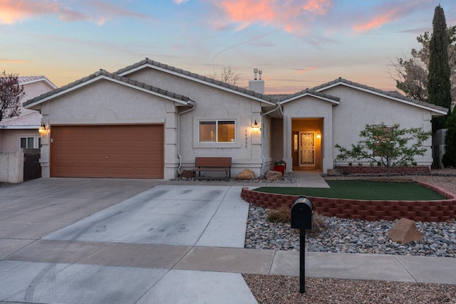 10335 Dunbar St NW, Albuquerque, NM 87114 - ranch-style home featuring a garage, concrete driveway, a tiled roof, and stucco siding