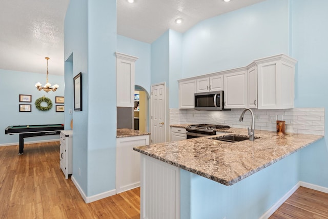 10335 Dunbar St NW, Albuquerque, NM 87114 - kitchen featuring tasteful backsplash, a sink, stainless steel appliances, white cabinetry, and light stone countertops