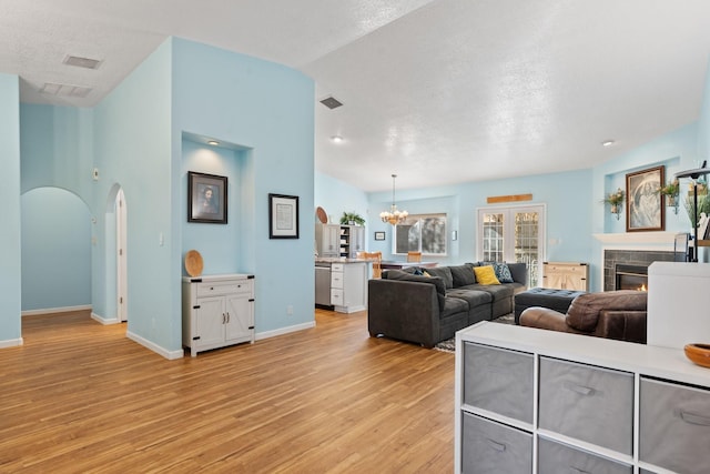10335 Dunbar St NW, Albuquerque, NM 87114 - living area with a chandelier, light wood-type flooring, a tiled fireplace, and visible vents