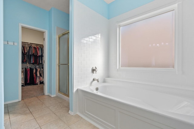 10335 Dunbar St NW, Albuquerque, NM 87114 - bathroom featuring a garden tub, tile patterned flooring, a shower stall, and a walk in closet