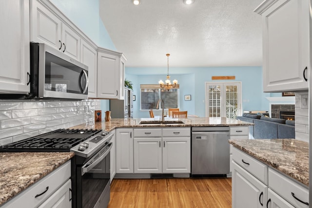 10335 Dunbar St NW, Albuquerque, NM 87114 - kitchen featuring a sink, light wood-style floors, appliances with stainless steel finishes, and tasteful backsplash