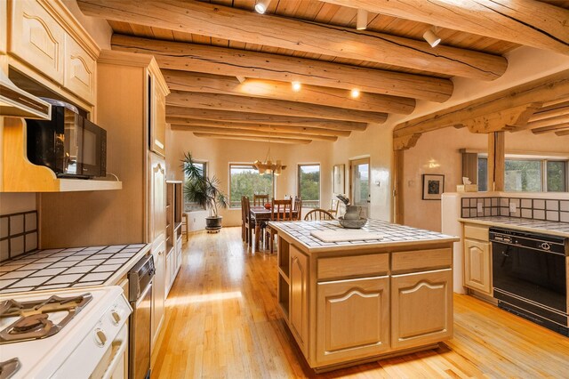 kitchen featuring plenty of natural light, tile counters, light wood-style floors, and black appliances
