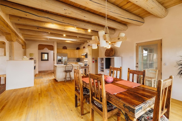 dining area featuring wood ceiling, beam ceiling, arched walkways, and light wood-type flooring