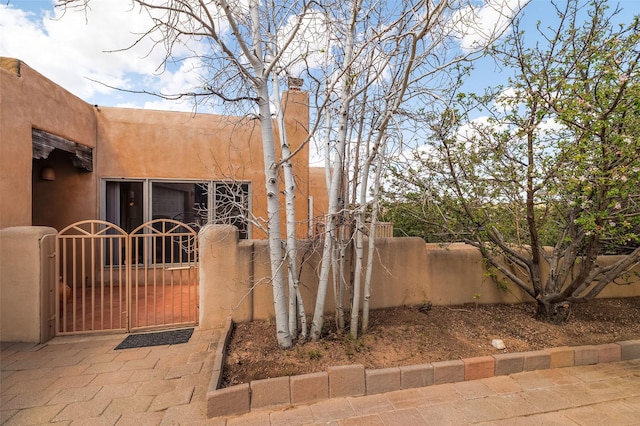 67A Blue Canyon Trl, Santa Fe, NM 87507 - view of side of property with a gate and stucco siding