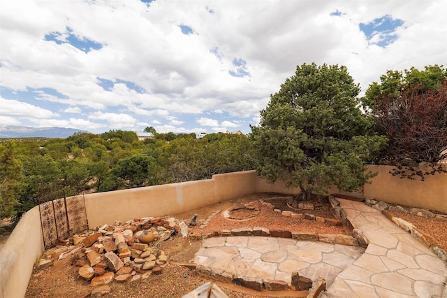 view of patio / terrace featuring a wooded view and a fenced backyard