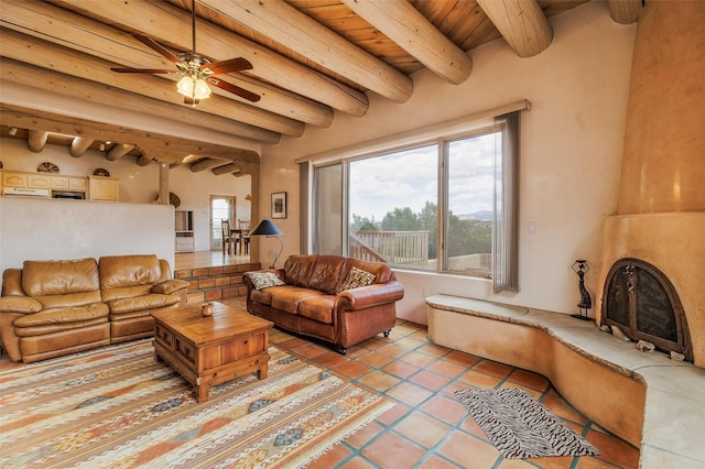living area with a fireplace with raised hearth, a ceiling fan, wooden ceiling, light tile patterned flooring, and beam ceiling