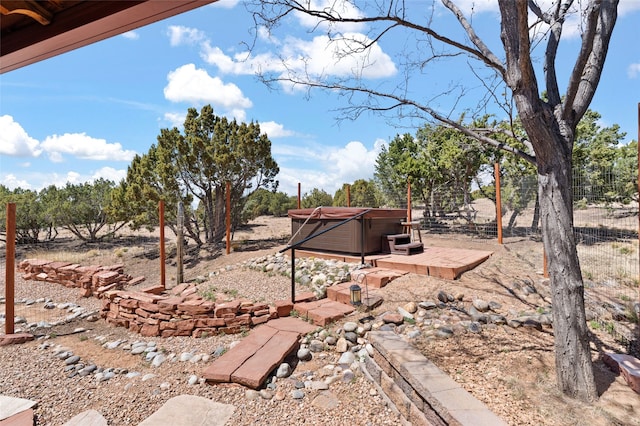 view of yard featuring fence and a hot tub