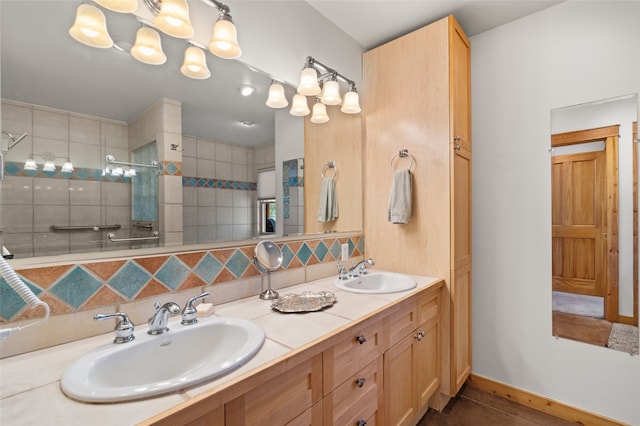 full bath featuring a tile shower, double vanity, decorative backsplash, and a sink