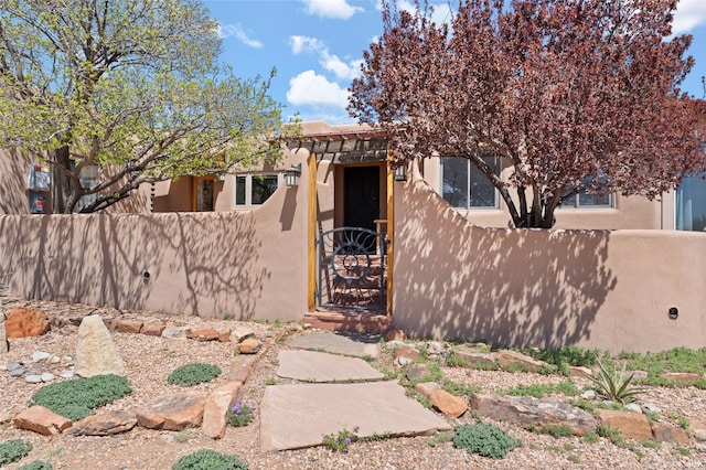 view of front facade with a gate, stucco siding, and a fenced front yard