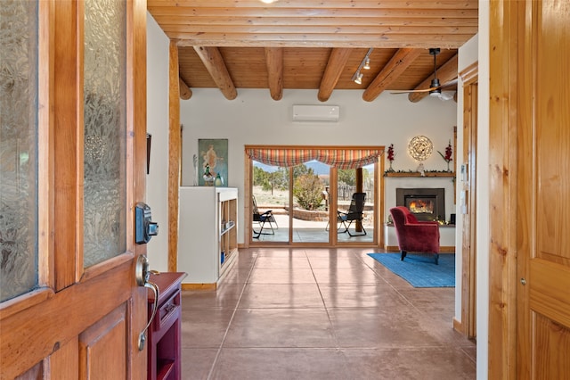 foyer entrance featuring beam ceiling, a wall unit AC, a glass covered fireplace, a ceiling fan, and wooden ceiling