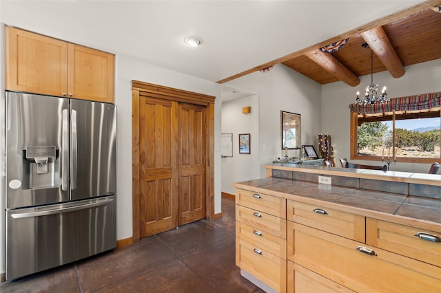 kitchen featuring light brown cabinets, tile counters, wooden ceiling, stainless steel refrigerator with ice dispenser, and beam ceiling